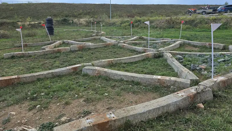 Labirint din grinzi de beton, cu celule umplute cu piatra si stegulete de traseu